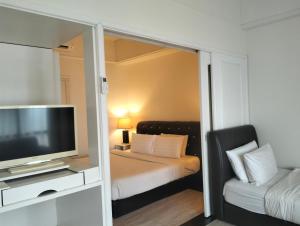吉隆坡的住宿－Luxy Service Apartment at Times Square KL，一间卧室配有一张床、一台电视和一张沙发