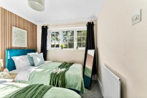 a bedroom with two beds and a window at Fantastic House in Bracknell - Garden - Games room in Bracknell