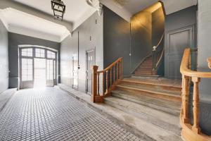 a hallway with a staircase with wood treads at TRIBUS-GITES URBAINS CARCASSONNE in Carcassonne