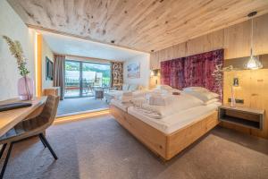 a large bedroom with a large bed and a desk at Hotel Wiesental in Obergurgl