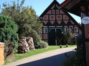 un vieux bâtiment avec une porte verte dans une cour dans l'établissement de lüt Ferienhof Jameln, à Jameln