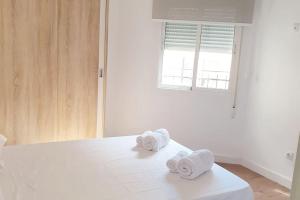 dos toallas sentadas en una cama en una habitación en Universidad cardenal Herrera, en Elche