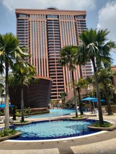 a resort with palm trees and a large building at Luxy Service Apartment at Times Square KL in Kuala Lumpur