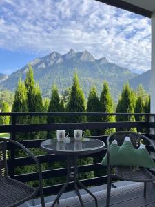 two coffee cups on a table on a balcony with mountains at Willa Magdalena in Sromowce Niżne