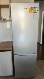 a white refrigerator in a kitchen next to a counter at Apartament Manasa in Bishkek