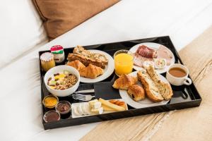 a tray filled with breakfast foods on a bed at Maison Pigalle in Paris