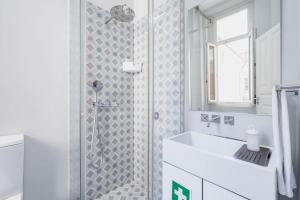 een witte badkamer met een douche en een wastafel bij Cozy Studio Arts Porto Downtown in Porto