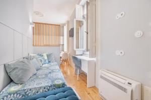 een kleine slaapkamer met een blauw bed en een bureau bij Cozy Studio Arts Porto Downtown in Porto