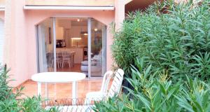 a patio with a white table and some plants at T2 Terrasse, Bormes Les Mimosas La Faviere, 5 Pers, 5 mn à pieds des plages et commerces in Bormes-les-Mimosas +32 photos