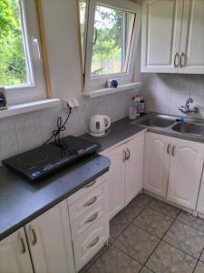 a kitchen with white cabinets and a sink at Leśna Chata kuracyjna nad rzeką z sauną w Borach Tucholskich in Bielska Struga +101 photos