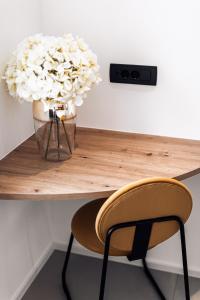 a desk with a chair and a vase of flowers at APARTMENTS Goldi Superior in Stahovica