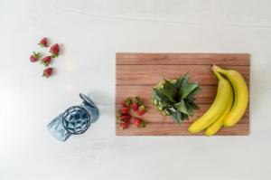 une planche à découper avec des bananes et autres fruits et légumes dans l'établissement White Cocoon Exclusive villas, à Naxos Chora