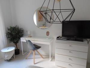 Zimmer mit einem Schreibtisch, einem TV und einem Stuhl in der Unterkunft Wald und Wiese in Kreuztal