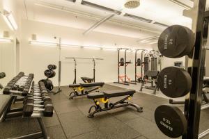a gym with several treadmills and weights at Hotel Stockholm North by FIRST Hotels in Upplands-Väsby