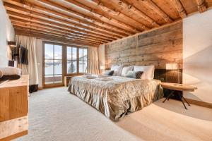 a bedroom with a large bed and a wooden wall at Chalet Lilly - Luxury by A-Appartments in Zug