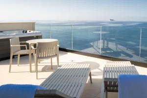 balkon ze stołem i krzesłami oraz widokiem na ocean w obiekcie Deep Blu Boutique Hotel w mieście Żurrieq