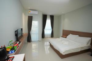 um quarto com uma cama e uma televisão em Athenee Hotel Vientiane em Vientiane