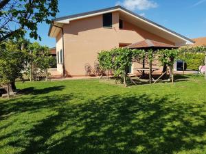 ein Haus mit einem Hof mit grünem Gras und einem Gebäude in der Unterkunft Deliziosa Villetta con Giardino in Marina di Casalvelino