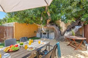 a table with fruit on it under a tree at Villa Serena - PlusHolidays in Calpe