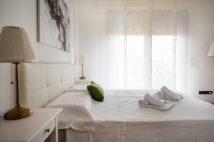 Un dormitorio blanco con una cama con toallas. en Attico vicino Milano, MXP, Rho Fiera, en Busto Arsizio