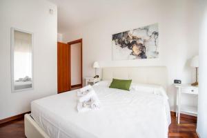 una camera da letto con un letto bianco e asciugamani di Attico vicino Milano, MXP, Rho Fiera a Busto Arsizio