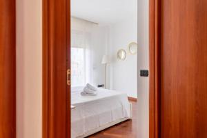 1 dormitorio con cama blanca y espejo en Attico vicino Milano, MXP, Rho Fiera, en Busto Arsizio