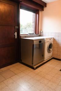 - un lave-linge dans une cuisine à côté d'une fenêtre dans l'établissement Kwakkelnest, à Poperinge