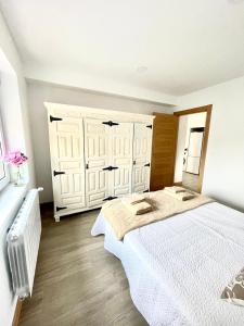um quarto com uma grande cama branca num quarto em Maysa em Santillana del Mar