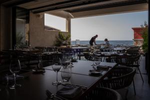 restauracja ze stołami i krzesłami z widokiem na ocean w obiekcie Deep Blu Boutique Hotel w mieście Żurrieq