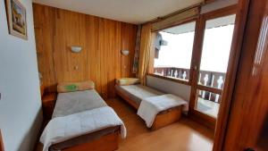 ein kleines Zimmer mit 2 Betten und einem Fenster in der Unterkunft APPART ZIG-ZAG LES COCHES in Les Coches