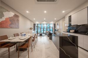 a kitchen and dining room with a long table and chairs at Metropole Thu Thiem Condo Apartment in Ho Chi Minh City