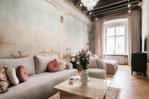 ein Wohnzimmer mit einem Sofa und einem Tisch in der Unterkunft Gallery 7 - LoftAffair Collection in Krakau
