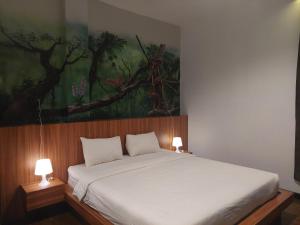 una camera da letto con un letto e un dipinto sul muro di Ladja Hotel Sintang a Sintang