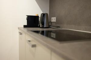 a kitchen counter with a microwave and a coffee maker on it at Keizersgracht Eindhoven in Eindhoven