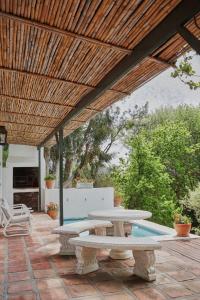 a patio with two picnic tables and a wooden roof at Little Willow Brooke in Franschhoek