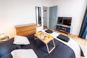 een slaapkamer met een groot bed en een tafel bij Confort au Stade de France ! in Saint-Denis