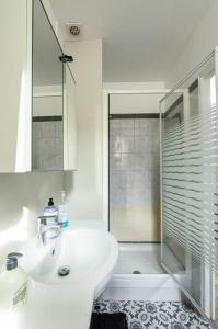 een witte badkamer met een wastafel en een douche bij Confort au Stade de France ! in Saint-Denis