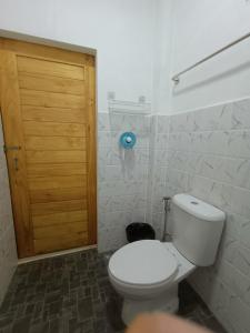 a bathroom with a toilet and a wooden door at Homehana Pua in Pua