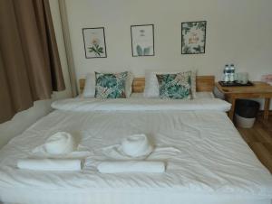 a bedroom with two beds with white sheets at Homehana Pua in Pua