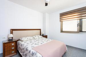 a white bedroom with a bed and a window at EDEN RENTALS Candelaria Melicoton Scape in Candelaria