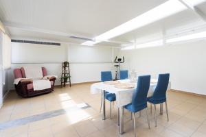 een eetkamer met een tafel en blauwe stoelen bij EDEN RENTALS Candelaria Melicoton Scape in Candelaria