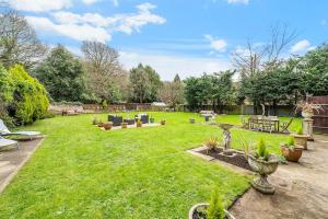 a garden with a lawn with tables and chairs at Pass the Keys Hidden Cottage in Esher, West End in Esher +7 photos