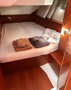 ラ・スペツィアにあるVelamica Bed on Boardのベッドにタオル2枚を用意した小さなキャビンです。