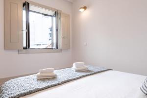 - une chambre avec un lit, un miroir et des serviettes dans l'établissement A Formosa - Premium @ Porto City Centre, à Porto