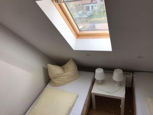 ワイマールにあるPension Alte Remise im Kammergut Tiefurtのベッドと窓が備わる小さな客室です。