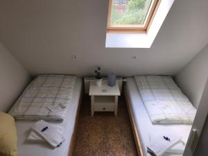 duas camas num quarto com uma mesa e uma janela em Pension Alte Remise im Kammergut Tiefurt em Veimar