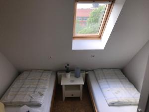 Duas camas num pequeno quarto com uma janela em Pension Alte Remise im Kammergut Tiefurt em Veimar