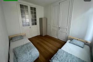 Cette petite chambre comprend deux lits et un réfrigérateur. dans l'établissement bken Aprt, à Anvers