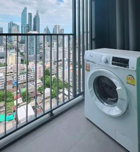 a washing machine in a room with a balcony at Chula samyan Bangkok in Bang Rak