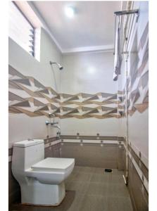 a bathroom with a toilet and a shower at Hotel Antonio's Nr Calangute Beach in Calangute